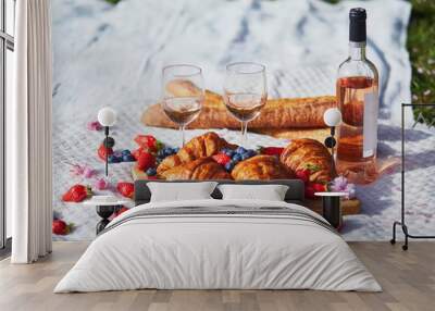 Beautiful picnic with rose wine, French croissants and fresh berries Wall mural