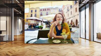 Girl drinking coffee and eating ice cream in Italian cafe Wall mural