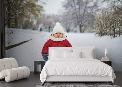 Happy smiling baby girl sitting in snow Wall mural