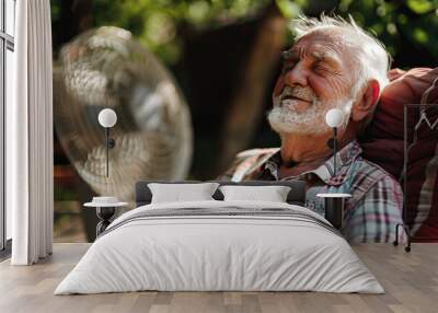 Old man relaxing near the ventilator, suffering from extremely high temperature, heat stroke and dehydration. Heat waves, global warming and climate change concept Wall mural