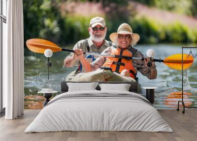 Senior couple kayaking on the river. Healthy elders enjoying summer day outdoors. Sportive people having fun at the nature. Active retirement concept Wall mural