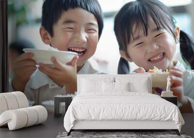 Two cheerful Asian kids sharing lunch at school. Wall mural