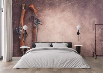 Two vintage duel pistols on wooden background Wall mural