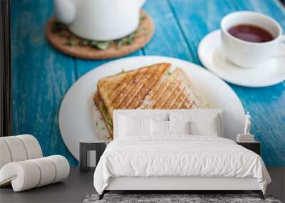 Tasty sandwich on a plate and a cup of tea Wall mural