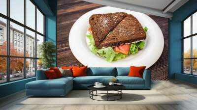 Two rye bread sandwiches with red fish and lettuce Wall mural