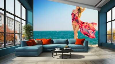 young woman in fluttering dress on beach Wall mural