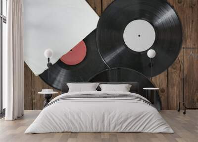 Three old vinyl records in paper case on wooden rustic background. Wall mural