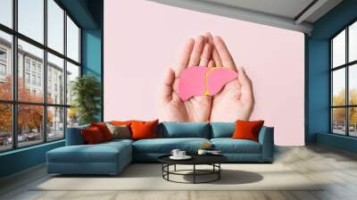 World hepatitis day. Adult hands holding donation liver on pink background. Awareness of prevention and treatment viral hepatitis. Liver cancer. World cancer day. copy space. banner Wall mural