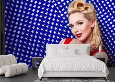 Holiday US Independence Day, the fourth of July. Beautiful young girl in retro style smiling on the background of the American flag. The blonde pinup. Postcard, advertising. Hair curls, red lips. Wall mural