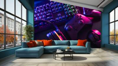 gamer work space concept, top view a gaming gear, mouse, keyboard, joystick, headset with rgb color on black table background. Wall mural