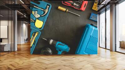 top view of Construction tools concept with Drill sets, hammer, screwdriver and Toolbox on black wooden background. Wall mural