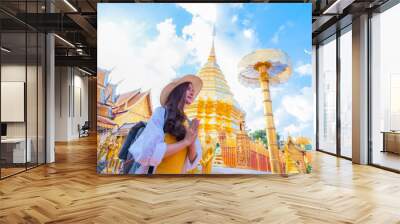 A young woman praying at Wat Phra That Doi Suthep, a famous tourist attraction and places of interest in Chiang Mai, Thailand Wall mural