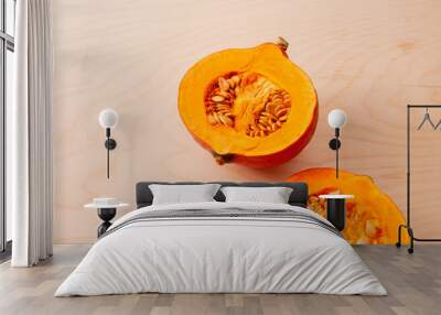 Two halves of raw pumpkin with seeds on wooden background Wall mural