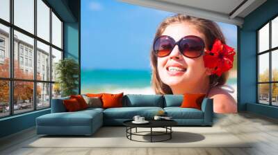 closeup of young woman in sunglasses smiling on beach Wall mural