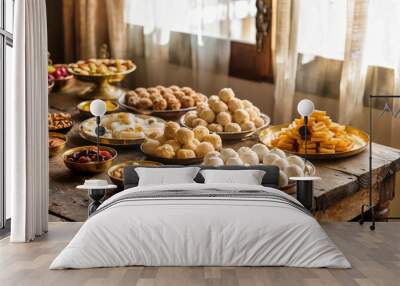 Traditional Indian Kitchen Table with Diwali Sweets and Brass Bowls in Sunlit Room Wall mural