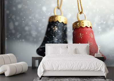 Two Christmas bells, one red and one black, on a snowy background. Wall mural