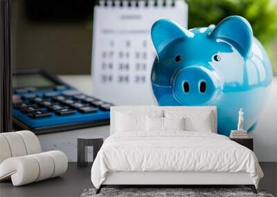 Piggy bank with a blue calculator and calendar on a white background representing financial goals and moneysaving concepts with space for copy Wall mural