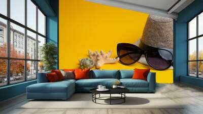 Summer accessories, shells, hat and sun glasses on yellow background. Summer vacation and sea concept. Wall mural