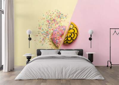 Top view of a fresh and delicious donut split or cut in two parts on a pink table Wall mural