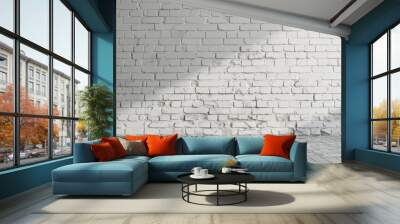 A white brick wall in a well-lit studio setting, providing a clean and minimalist background. The light creates soft shadows on the wall, adding depth and dimension. Wall mural