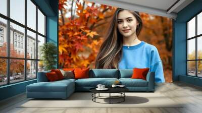 Portrait of a young woman wearing a crewneck blue mockup sweatshirt with fall colors and themed background for autumn season female fashion Wall mural