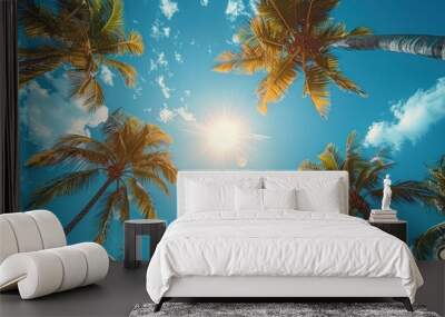 upward view of palm trees against a bright blue sky with sun glare Wall mural