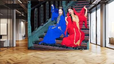 portrait of a beautiful women in oriental dress. grace and beauty. young girls in a red and blue dre Wall mural