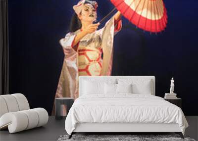 Traditional Japanese performance. Actress in traditional kimono and fox mark dancing with umbrella. Wall mural