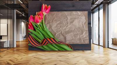 9 May background - template blank greeting card with red tulips, George ribbon and paper note on the wooden background. Victory day or fatherland defender day concept. Top view, copy space for text Wall mural