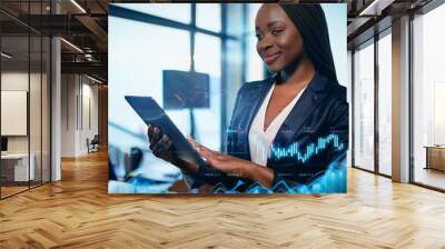 A businesswoman analyzes sales data on his tablet, immersed in financial reports and growth charts. Her focused gaze reflects a commitment to data-driven decisions and strategic success. Wall mural