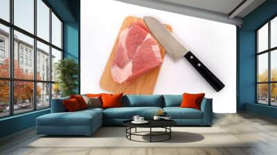 A piece of raw meat on a cutting board and a knife on a white background Wall mural