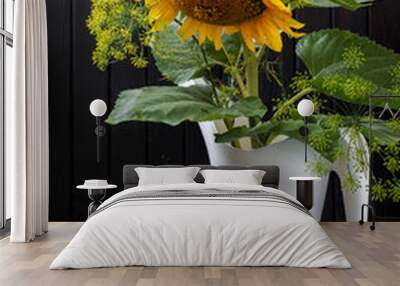 a sunflower flower in a watering can and two nectarines on a dark wooden background.Still-life Wall mural