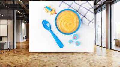 Baby food. Fresh homemade applesauce. Blue bowl with fruit puree on fabric and kids toys on table. The concept of proper nutrition and healthy eating. Organic and vegetarian food. Copy space for text Wall mural