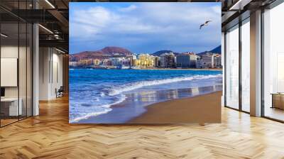  Las-Palmas de Gran Canaria, Spain, on January 8, 2018. The winter sun lights the Playa de Las Canteras beach on the bank of the Atlantic Ocean. beautiful embankment in the distance Wall mural