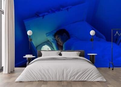 boy sleeping with led night lamp, soft focus Wall mural