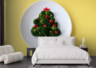 Christmas edible tree made from broccoli, tomato and corn on a white plate. Christmas card with gifts and dietary salad. Yellow background, copy space, flat lay. Wall mural