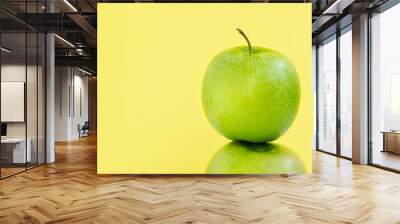 one green Apple on another on yellow background Wall mural