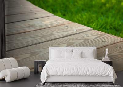 Wooden table in diagonal on the image with blurred summer green background Wall mural