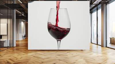 Glass of red wine. Red wine is poured from a bottle into a glass. Wall mural