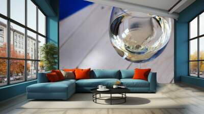 Glass of white wine on the woody table with blue beckground Wall mural