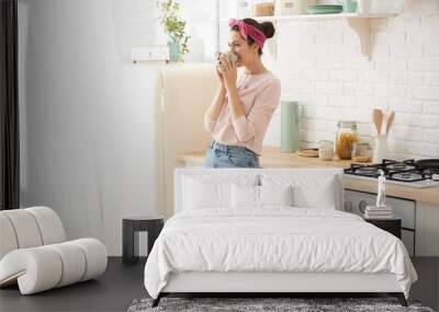 Young woman drinking a morning coffee in kitchen
 Wall mural