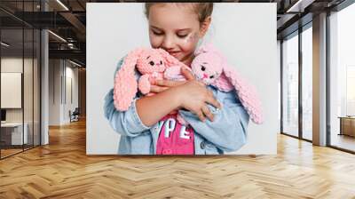 Cute little kid girl holding handmade knitted soft toy on white Wall mural