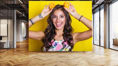 Fashion summer portrait funny indian girl with oranges over yellow background. Diet cincept Wall mural