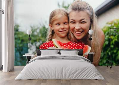 happy mother and daughter eating watermelon and having fun outdoor in summer day Wall mural