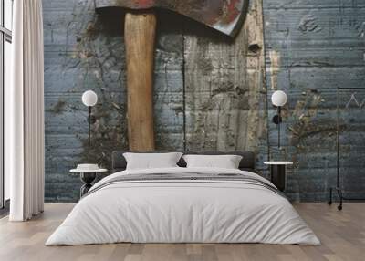 A rustic axe with a wooden handle lies on an old wooden surface, showcasing signs of use and wear, hinting at a story of hard work and labor. Wall mural