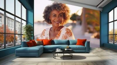 Lifestyle portrait of happy mature black woman with curly hair on tropical vacation standing on boardwalk Wall mural