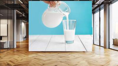 Milk is poured from a jug into a glass. Kefir or vegetable, alternative nut milk. Place for text Wall mural