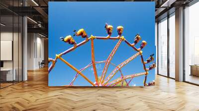 Extreme ride in motion in amusement park at sunny day Wall mural