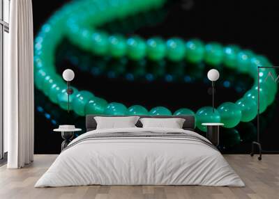 Green nephritis beads isolated on black background Wall mural