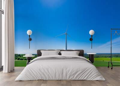 Panoramic shot from a bird's eye view of wind turbines in the middle of fields. Wind turbine construction in green field blue sky to generate renewable clean energy. concept idea eco energy energy. Wall mural